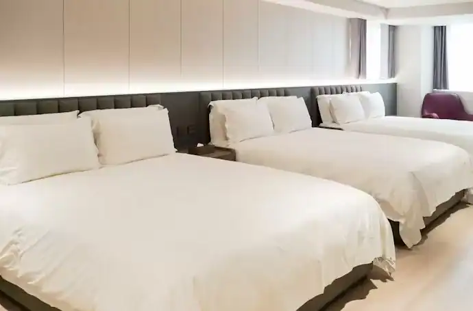 塔木德酒店評價：塔木德酒店六人房房型，設有三張雙人床與寬敞木質地板空間，整體採用柔和燈光與簡約設計風格，適合家庭或團體入住，展現舒適與實用兼具的住宿環境。
