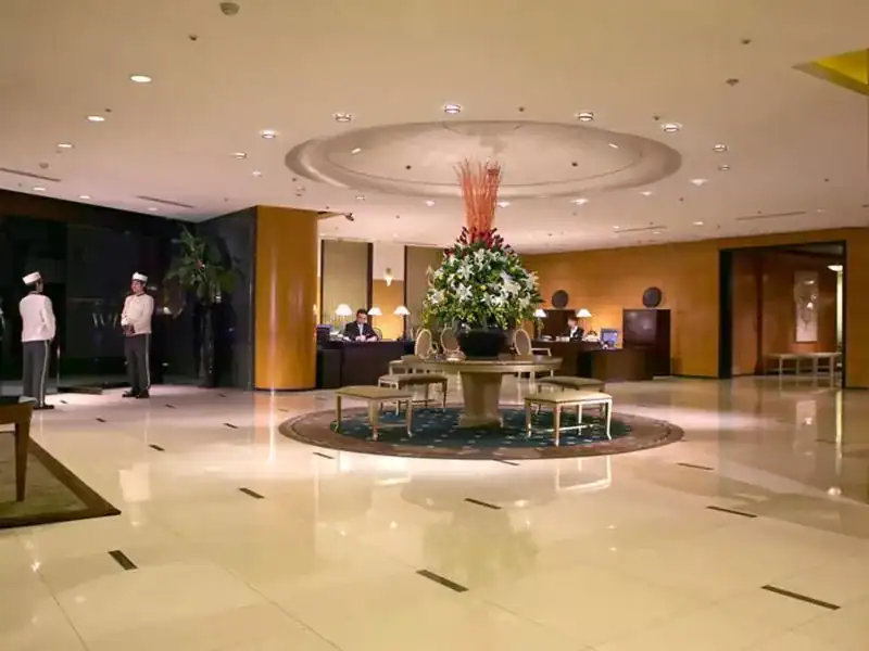 台中西區住宿：飯店大廳寬敞明亮，中央擺放大型花藝裝飾，服務人員整齊待命接待賓客