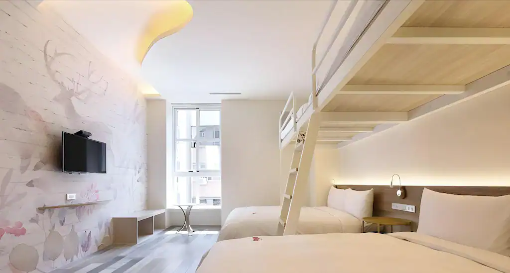 台中商旅樓中樓客房，白色旋轉梯連接上層臥鋪空間