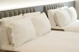 塔木德酒店台灣大道館客房內的雙床設計，白色床組與柔軟枕頭呈現台中商旅安靜舒眠的住宿環境。