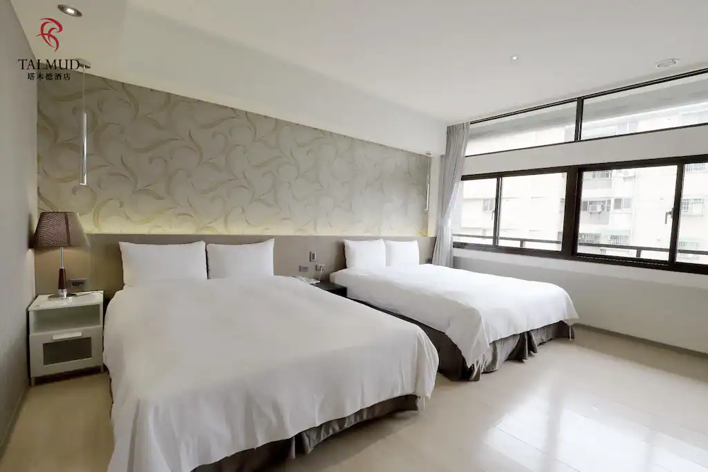 台中商旅推薦塔木德酒店台中台灣大道館雙床客房空間，包含兩張單人床與大面窗戶採光。
