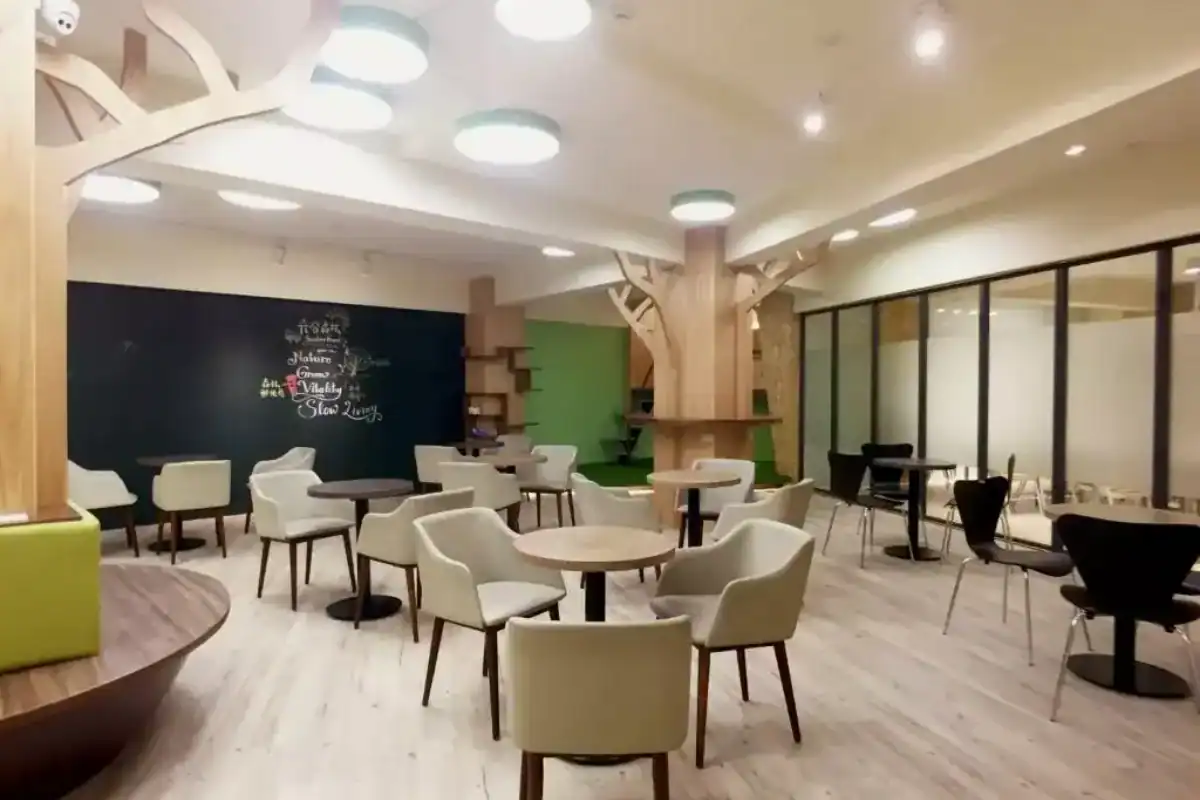 葉綠宿旅館逢甲館大廳實景，木質設計與圓桌座位配置，屬於逢甲夜市周邊的台中便宜住宿選擇之一。
