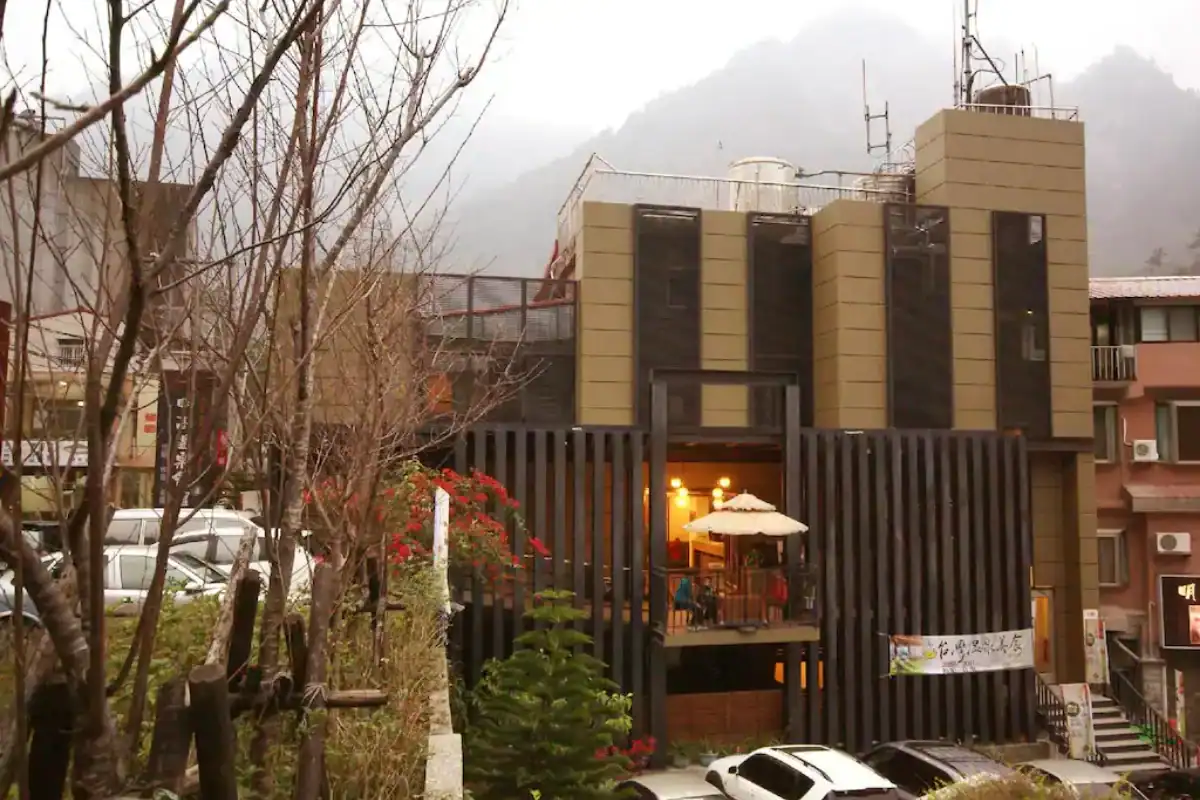 谷關明高溫泉會館的建築外觀座落於山景之中，呈現樸實安靜的谷關住宿氛圍。