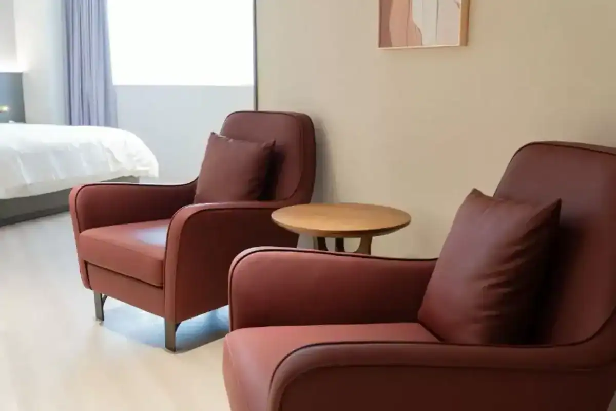 塔木德酒店台灣大道館客房內的雙人沙發與小茶几，呈現台中商旅舒適放鬆的休憩空間。