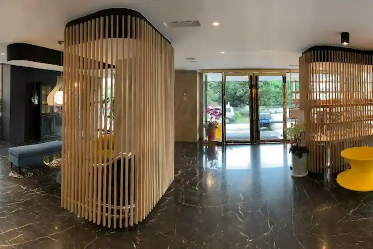 塔木德酒店台中館大廳空間畫面，木質格柵設計搭配黑色石紋地板與明亮採光，整體風格現代簡約且動線寬敞，是逢甲夜市附近住宿中兼具設計感與舒適度的選擇。
