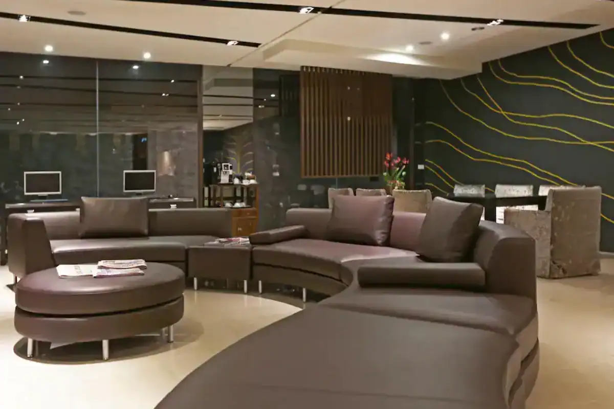 KUN Hotel 逢甲館大廳公共休憩空間,設有弧形沙發座位區與電腦使用區,是台中逢甲飯店住宿選擇之一。