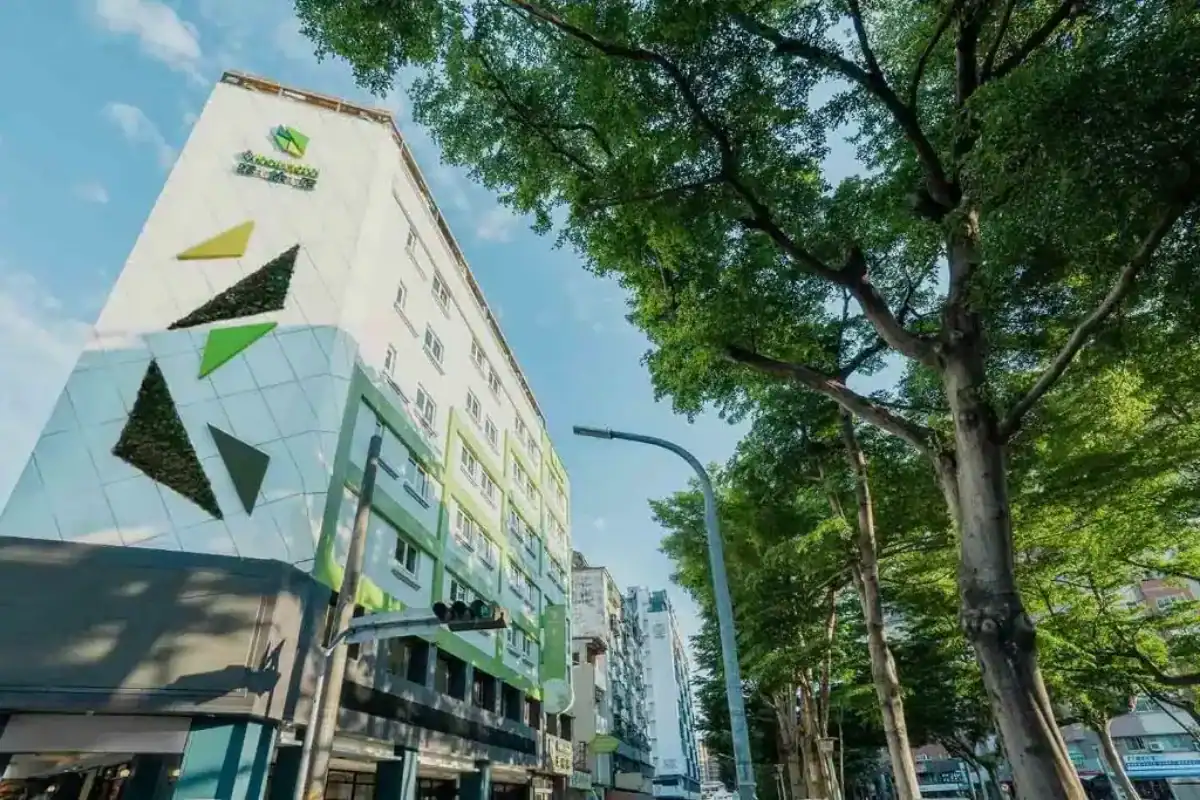 葉綠宿逢甲館外觀畫面，建築立面以綠色幾何設計搭配植栽元素，周邊綠樹成蔭且採光良好，整體氛圍清新自然，是步行可達商圈的逢甲附近住宿選擇之一。