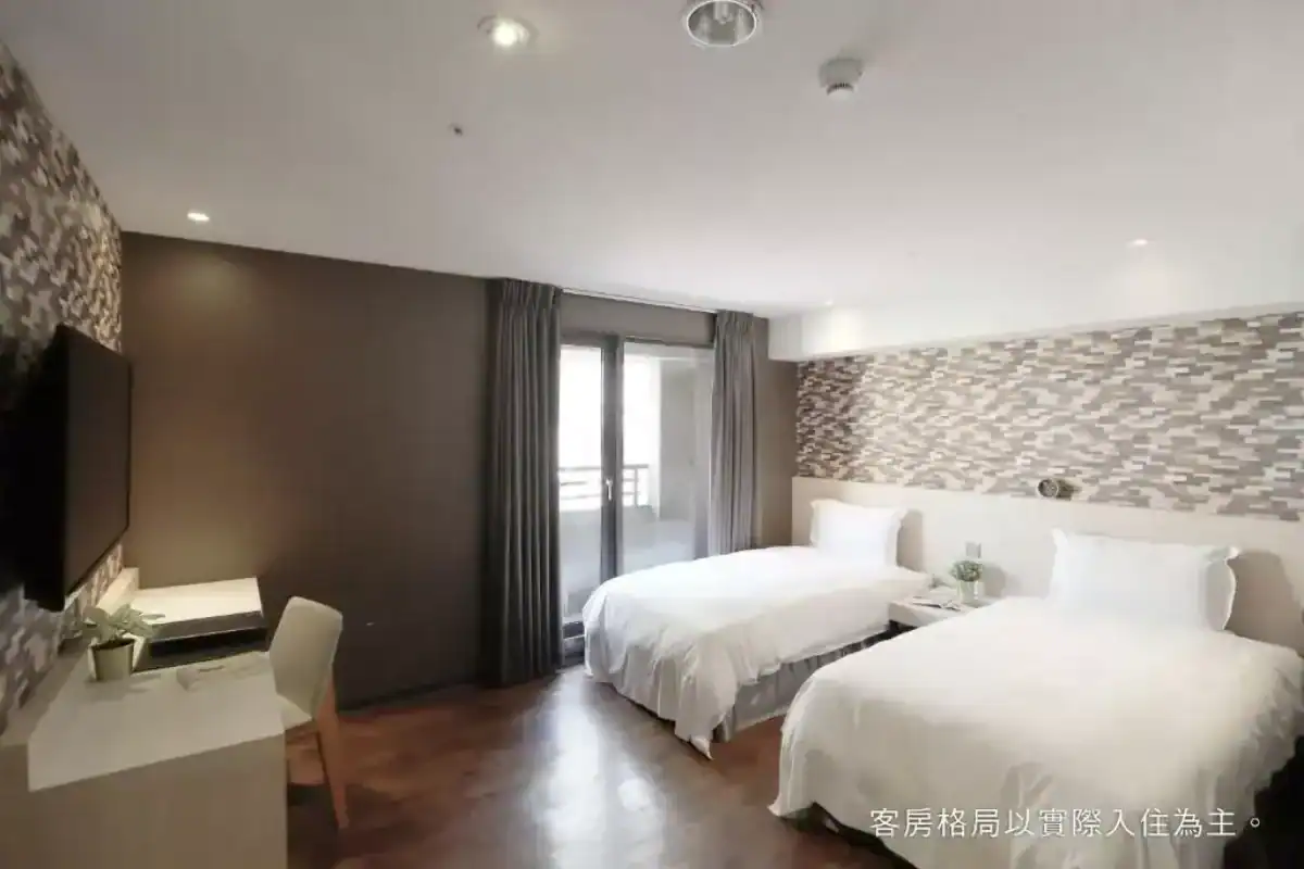 塔木德酒店台中一中館客房設計簡約明亮，提供兩張舒適大床與陽台空間，是一中街住宿熱門選擇。