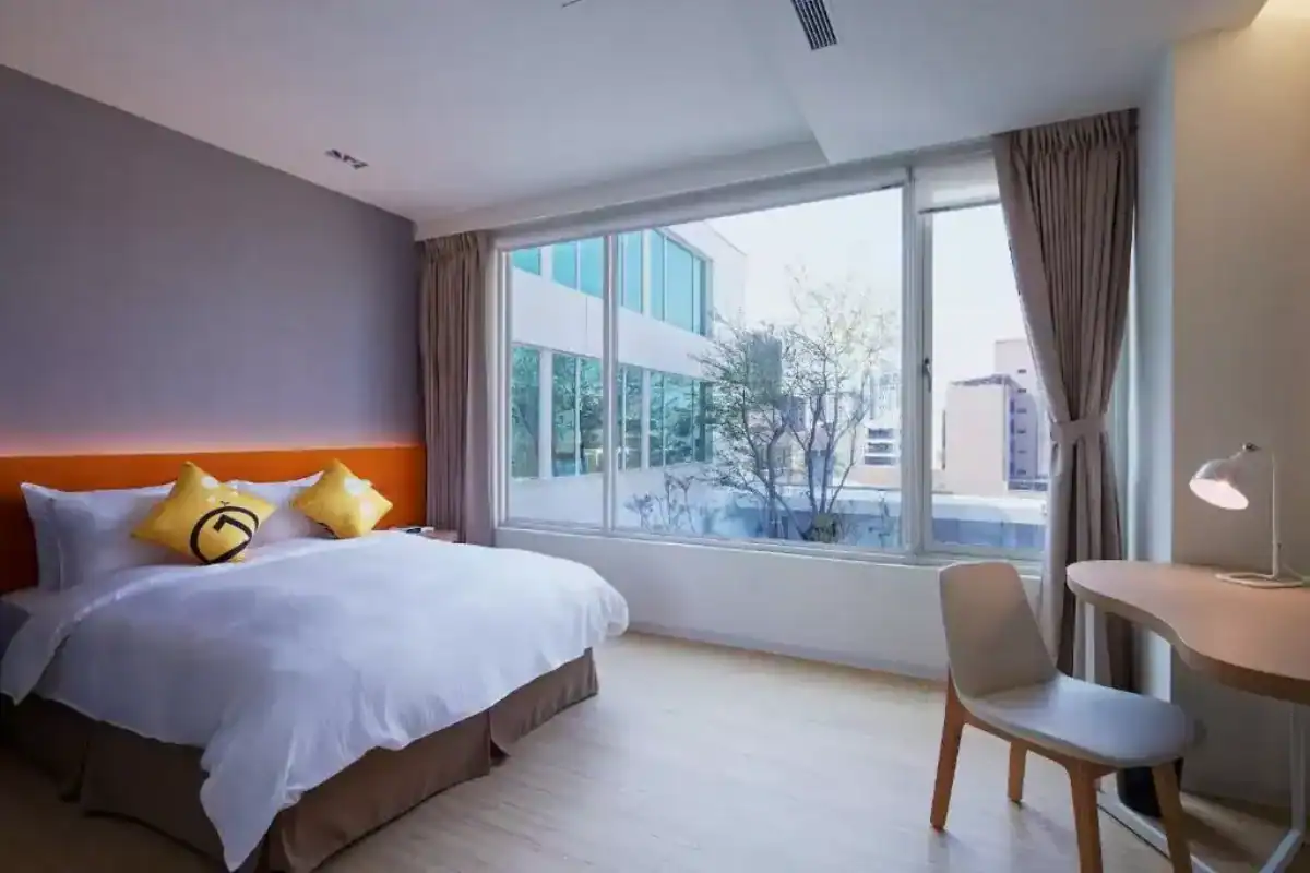 台中西區住宿：明亮現代風客房，大片窗景引入自然光，搭配簡約書桌與舒適大床