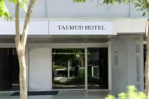 塔木德酒店台灣大道館外觀入口,白色立面搭配簡潔招牌設計,整體風格低調俐落,地點位於主要幹道旁,交通便利,是講求實用與位置優勢的台中飯店推薦之一。