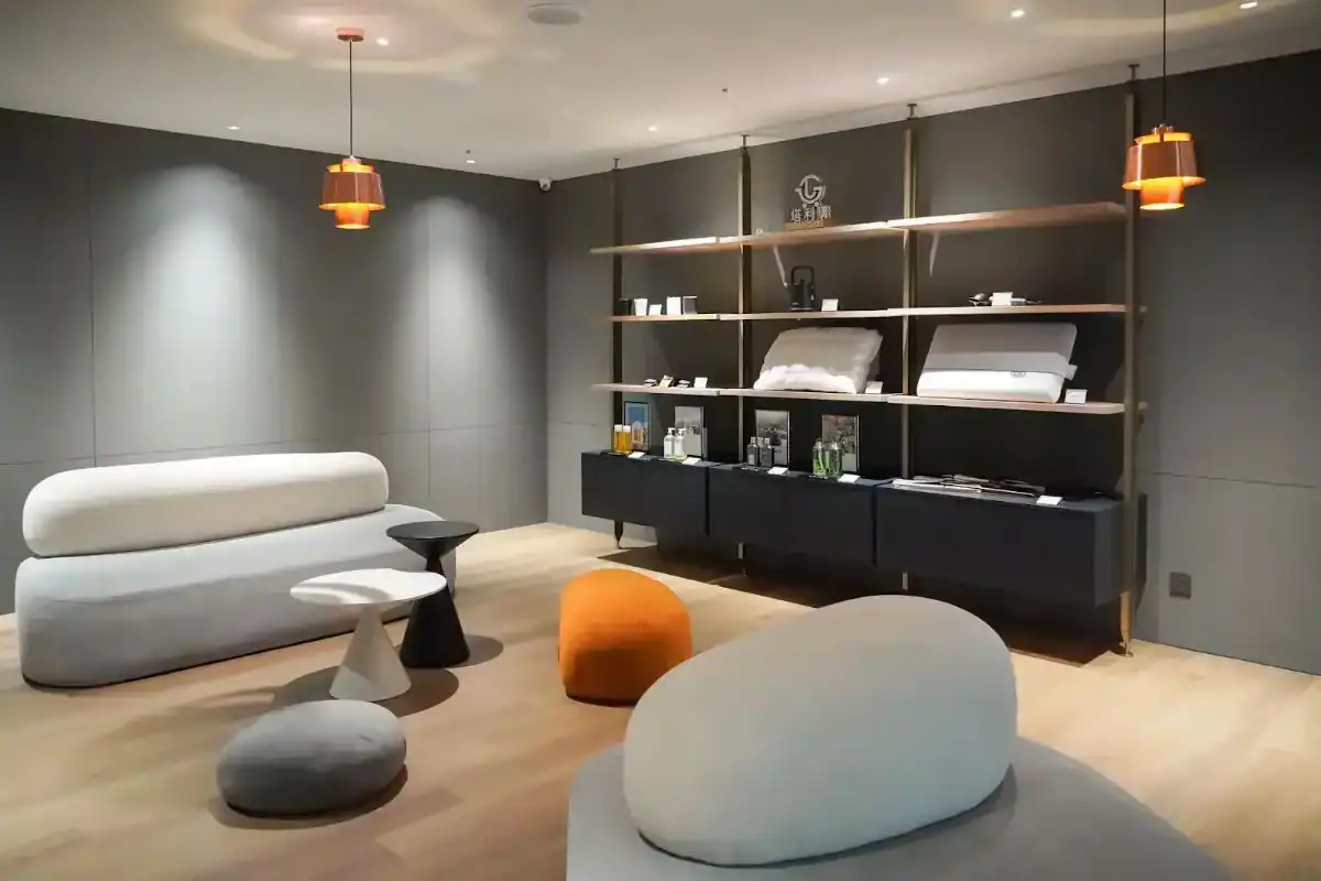 台中西區住宿：飯店交誼空間採現代極簡設計，柔和燈光搭配圓弧沙發與展示架，營造舒適雅緻氛圍