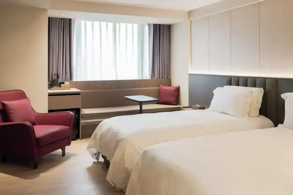 台中西區住宿：塔木德酒店台中館現代雙床客房，設有沙發與自然採光窗