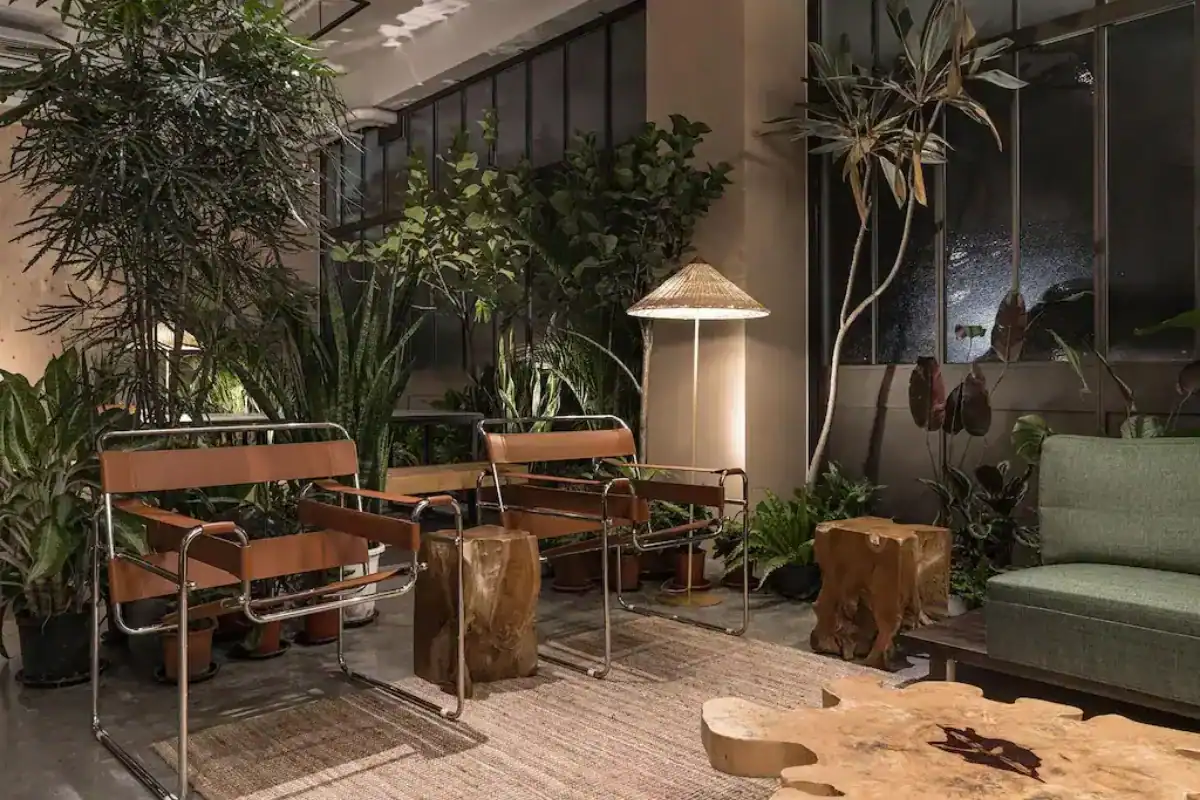 台中西區住宿：飯店大廳綠意盎然，木質桌椅與植栽搭配柔光燈，營造自然放鬆氛圍