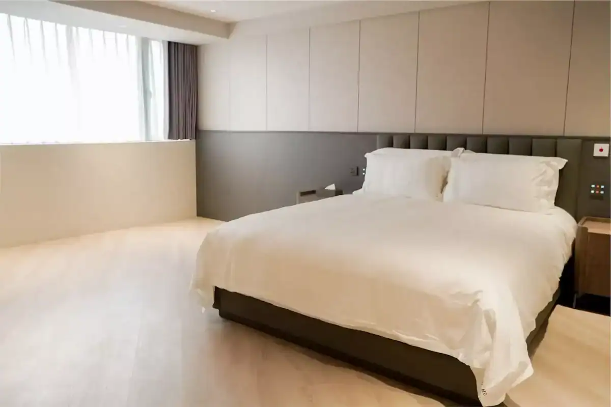 塔木德酒店評價：塔木德酒店台灣大道館無障礙客房，設有一張大床與柔軟白色寢具，房間以淺木地板與灰米色牆面呈現簡約風格，大片窗戶引入自然光，空間寬敞明亮、動線平整無障礙。