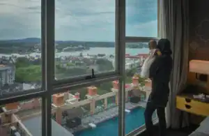 台中親子飯店推薦:媽媽抱著寶寶從飯店房間窗邊看城市風景(圖片來源:Pexels)