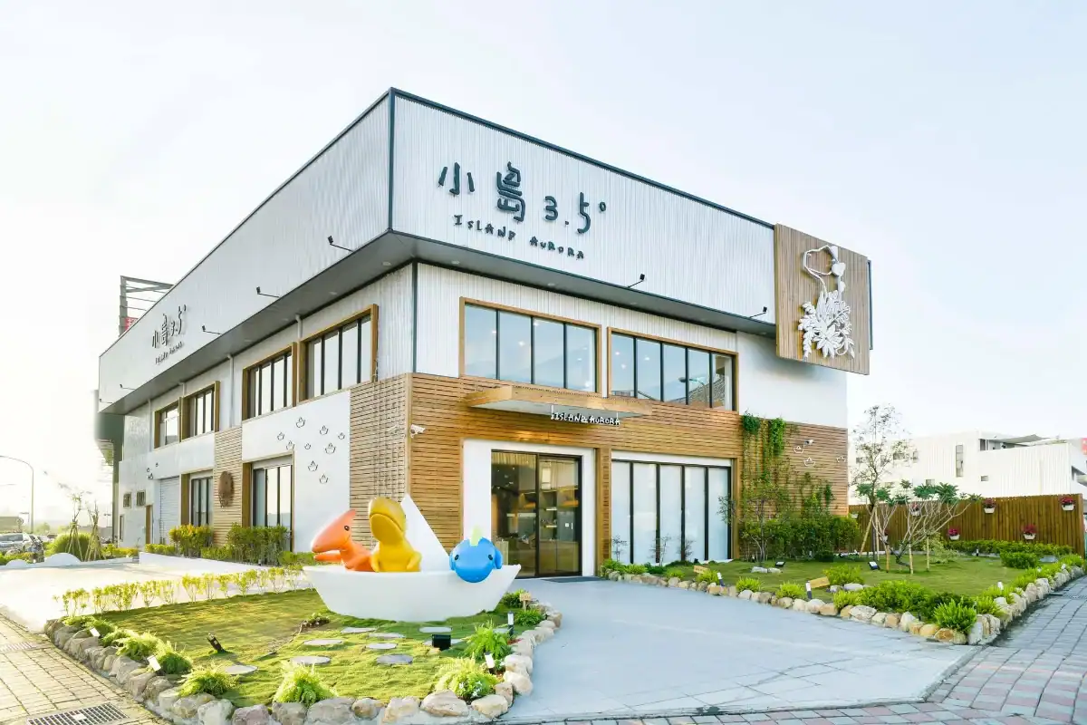 小島 3.5 度 Island Aurora 的白色兩層樓建築外觀與門前草皮,台中室內景點裡用低消換不限時遊玩的北屯親子餐廳